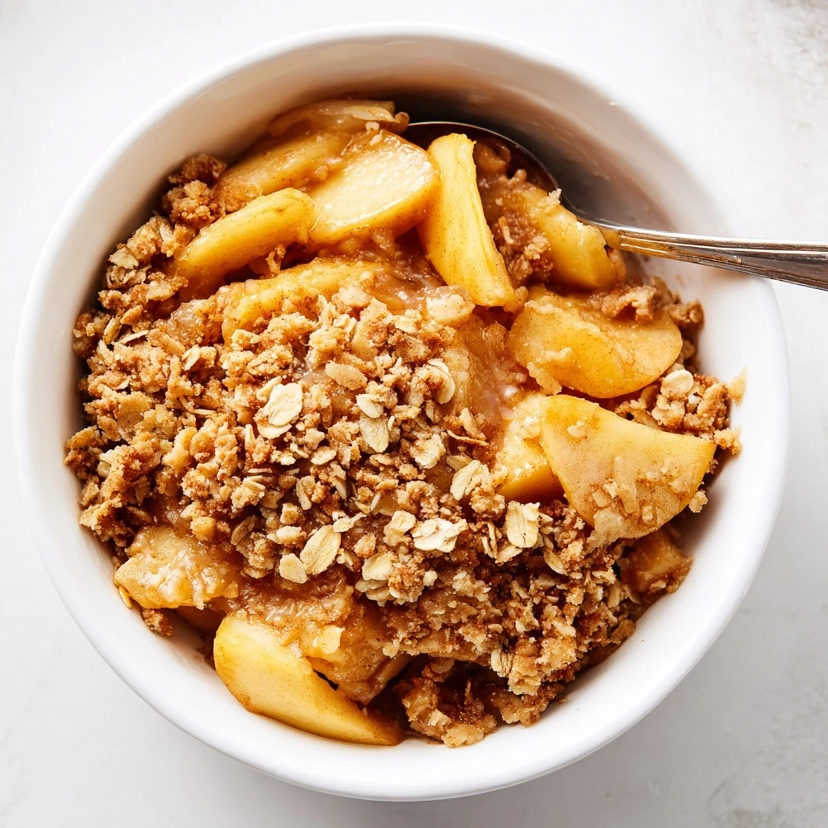 Freshly baked Apple Crumble with a golden, buttery topping and warm cinnamon-spiced apples bubbling in the dish.