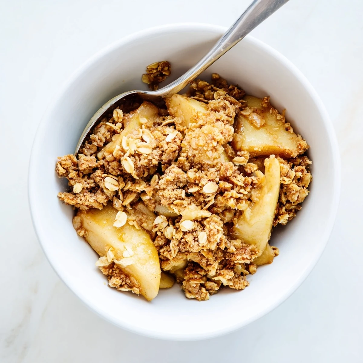 Homemade Apple Crumble served warm in a rustic dish, perfect with a scoop of vanilla ice cream melting on top.