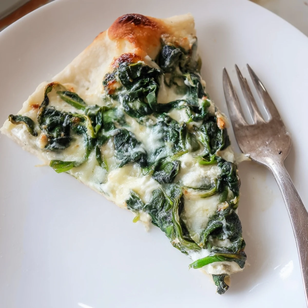 Fresh Spinach Ricotta Pizza on a white plate, served with a crisp side salad and red pepper flakes.