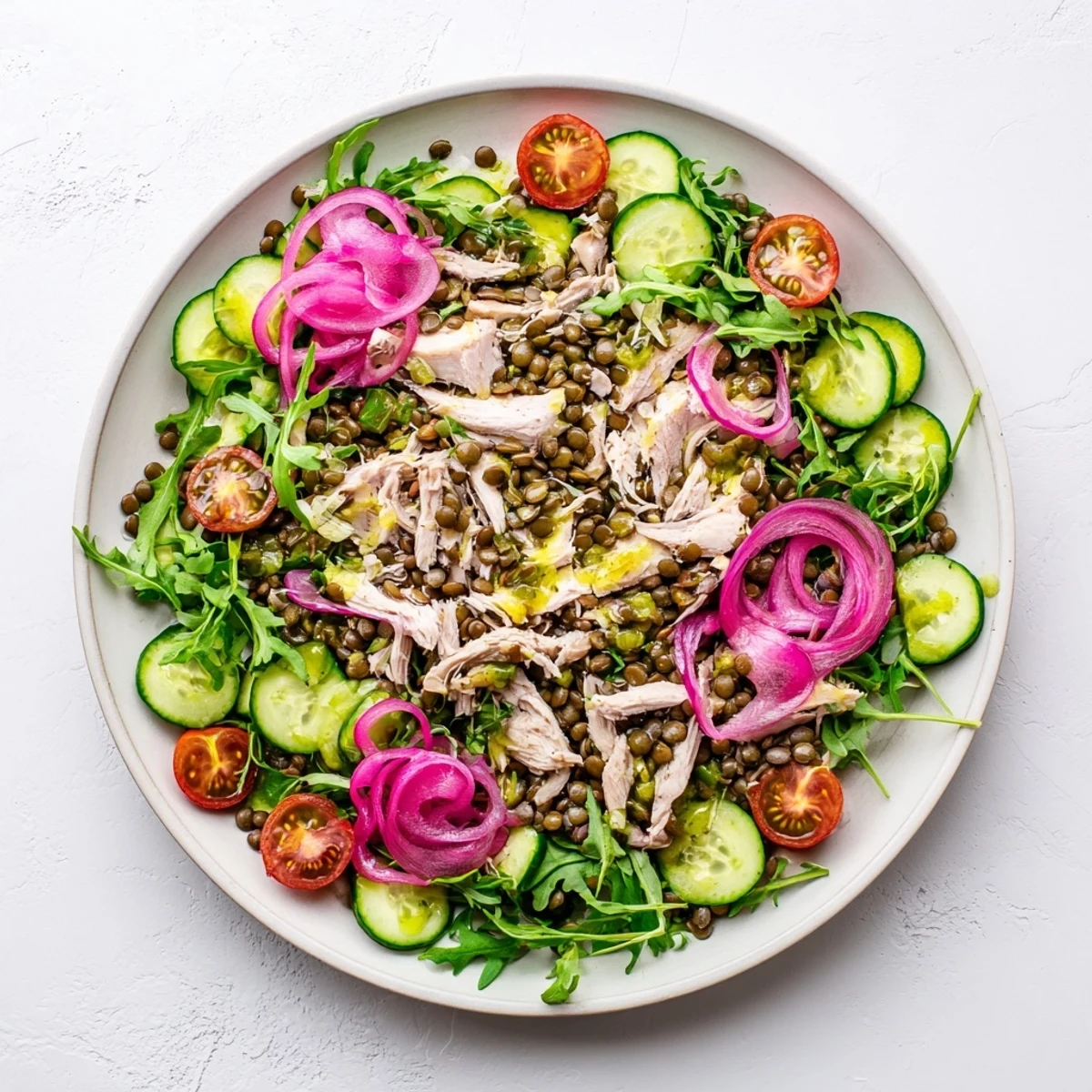 A close-up of the vibrant Lentil & Chicken Spring Salad with tender lentils, juicy roasted chicken, and peppery arugula in a zesty mustard dressing.