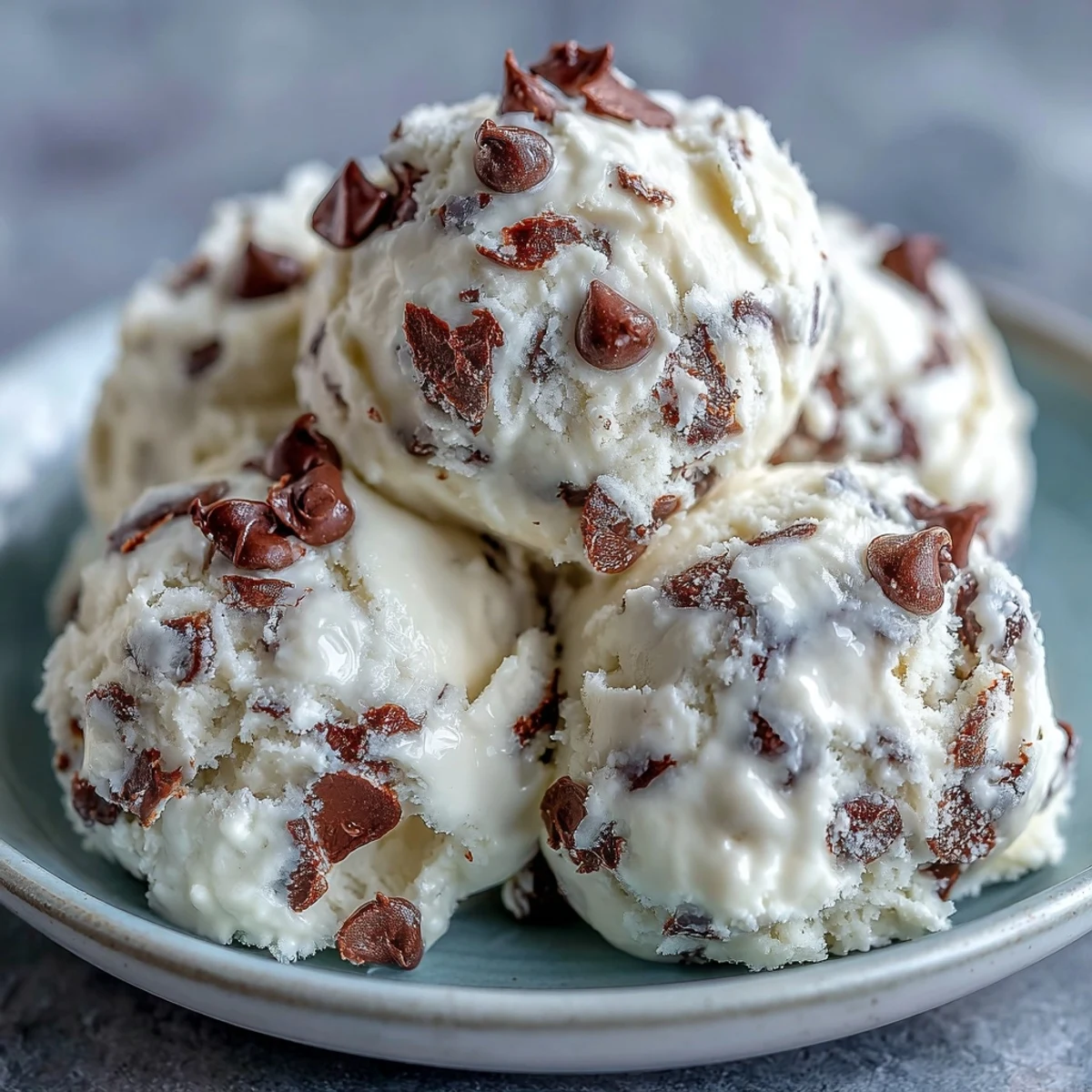 Creamy Greek Yogurt Cookie Dough is scooped from a bowl, featuring rich chocolate chips and a chilled, indulgent texture.