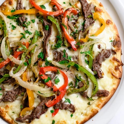Golden-brown Philly Cheesesteak Pizza fresh from the oven with bubbly melted cheese and peppers.