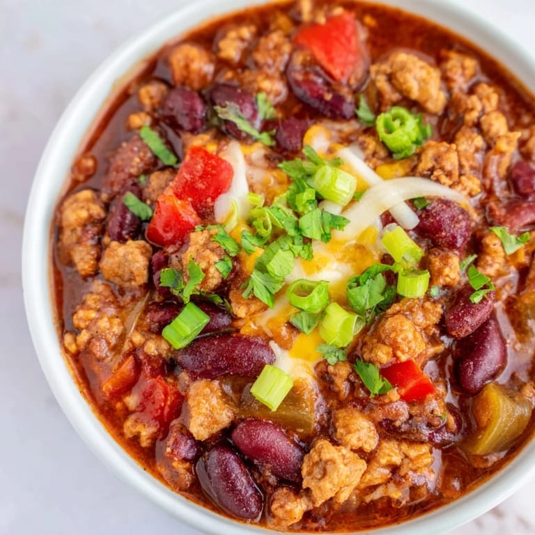This hearty Turkey Chili features lean ground turkey, beans, and tomatoes in a rich, warming broth.
