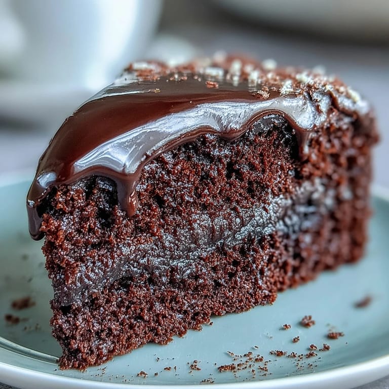 Perfectly piped chocolate icing decorates the top of an Easy Chocolate Fudge Cake, showcasing its super-squidgy, indulgent texture for a celebration.