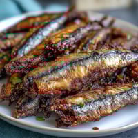 Crispy fried catfish fillets with golden cornmeal crust, served alongside zesty remoulade sauce for a classic Southern meal.  